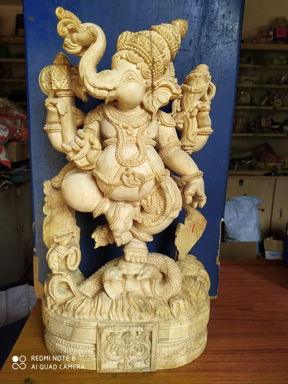Carved wooden sculpture of a seated figure, hand-finished in natural timber